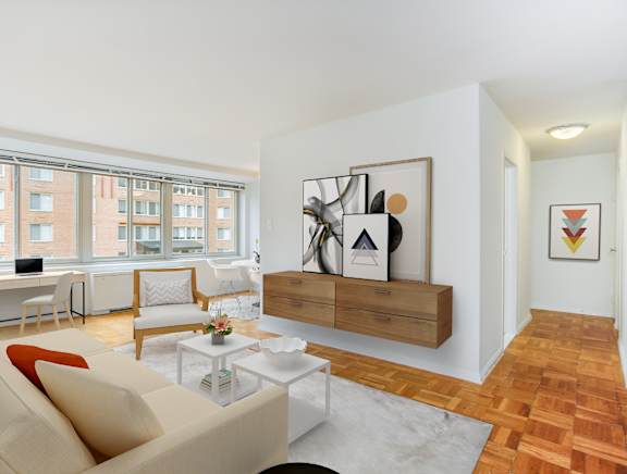A living room with a couch, a coffee table, and a painting on the wall.