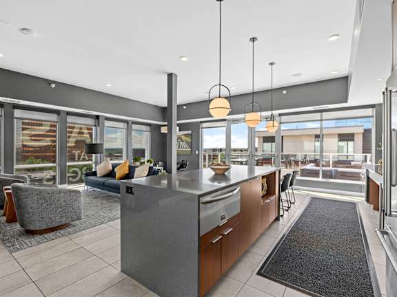 A modern kitchen with a large island and a view of the outdoors.