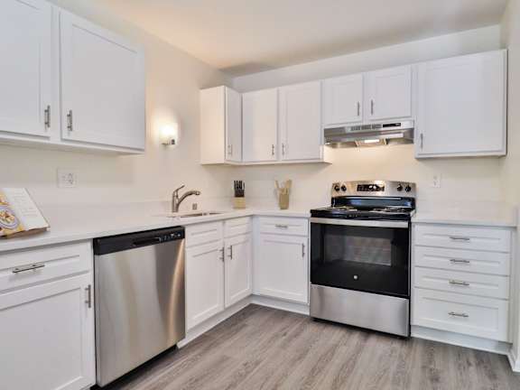 A kitchen with white cabinets and stainless steel appliances.