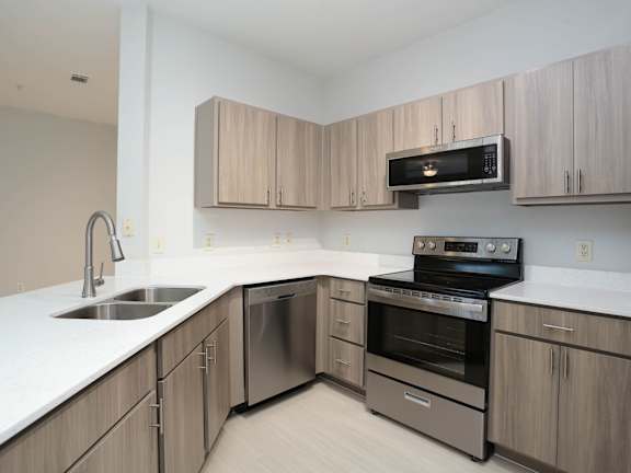 A kitchen with a sink, stove, and microwave.