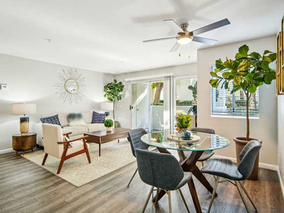 A modern dining room with a glass table and chairs.