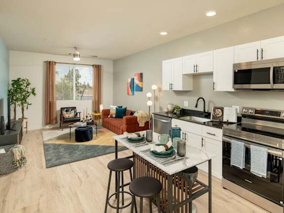 A modern kitchen with a dining table and chairs in the middle.