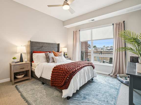 A bedroom with a large bed and a ceiling fan.