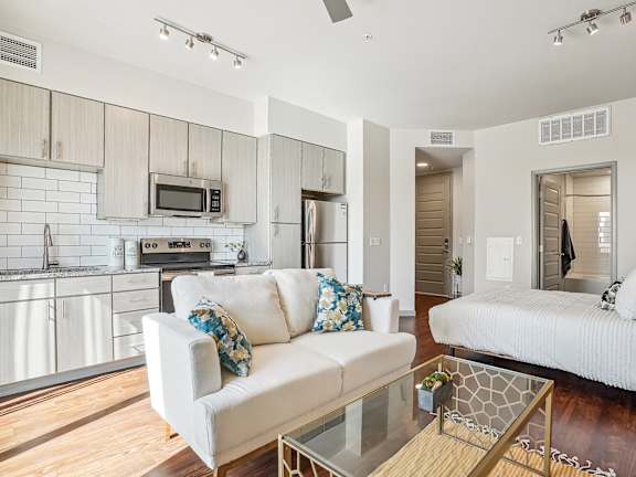 a living room and kitchen with a couch and a table