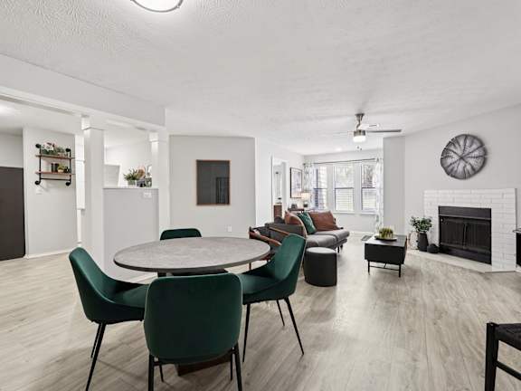 A modern living room with a fireplace and a dining table set up.