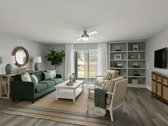 A living room with a white coffee table, green couch, tan chairs, and a sliding glass door.