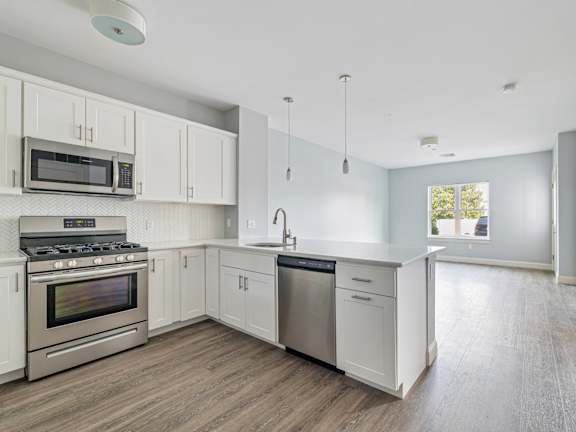 Kitchen with cabinets and appliances at Four Winds Apartments, Fall River