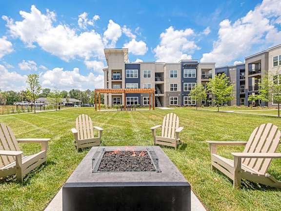 An aerial view of a swimming pool surrounded by lounge chairs and buildings in the background at The Percy Apartments, Nashville, TN, 37214