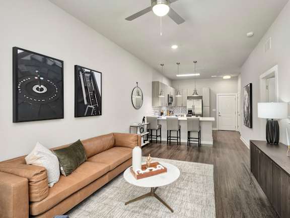 A living room with a tan couch and a coffee table in the middle at The Percy Apartments, Nashville, TN, 37214