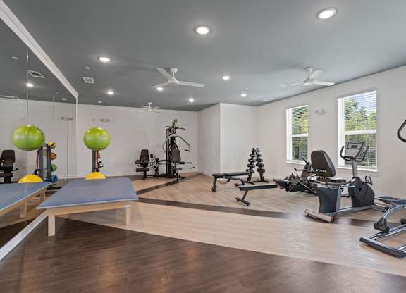 Ovata at Reedy Creek Senior Apartments in Charlotte NC Fitness Center with elliptical, stationary bike, dumbbells, benches, yoga balls, chest press and leg press.