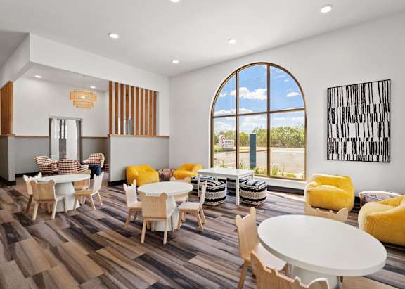 a dining room with tables and chairs and a large window
