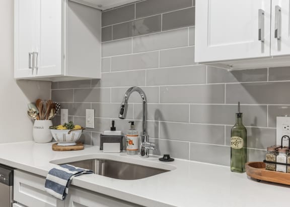 a kitchen with white counter tops and a sink at St. Andrews Reserve Apartments in Wilmington, NC