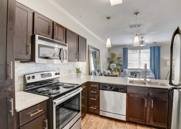 an updated kitchen with stainless steel appliances and wooden cabinets