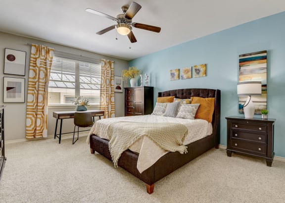 a bedroom with a bed and a ceiling fan