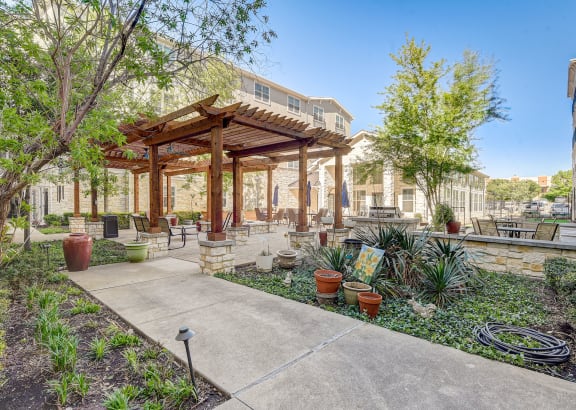 a patio with a pavilion and plants and trees