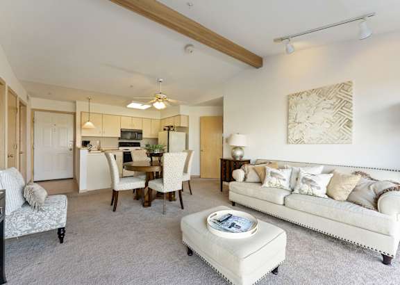 a living room filled with furniture and a ceiling fan