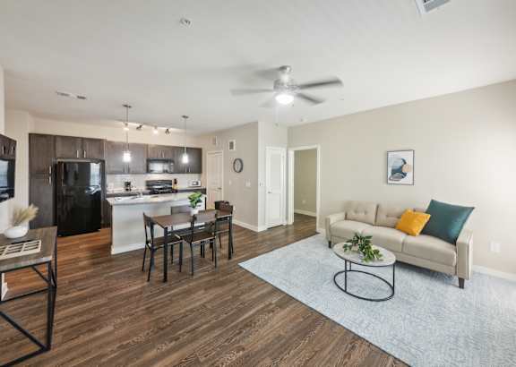 a living room filled with furniture and a ceiling fan
