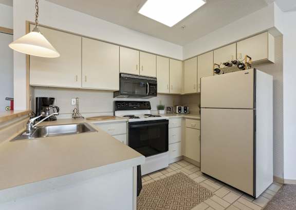 a kitchen with white cabinets and a granite counter top