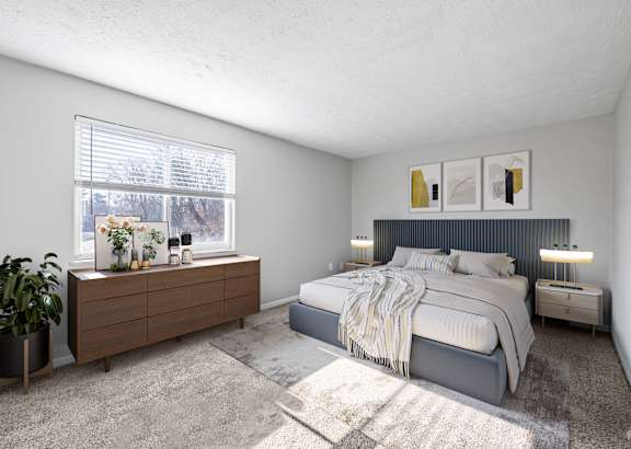 A bedroom with a large bed and a wooden dresser with a plant on it.