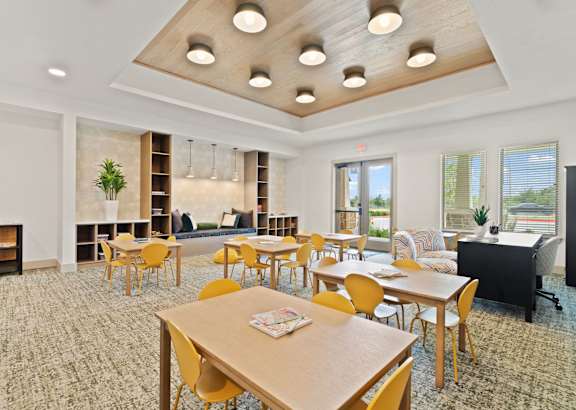 A room with a fireplace and a long table with chairs.