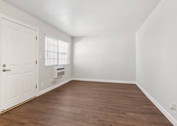 A room with a white door and a window with blinds.