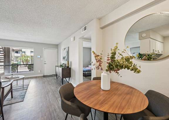 A dining room with a round wooden table and chairs.