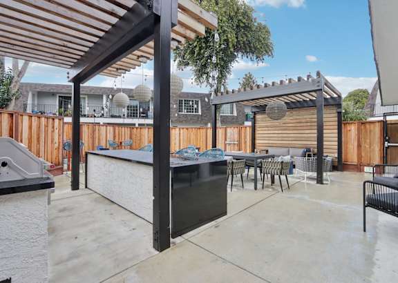 A patio with a barbecue grill and seating area.