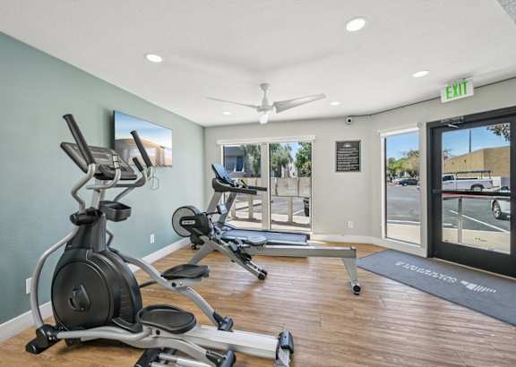 A gym with a row of exercise bikes and a treadmill.