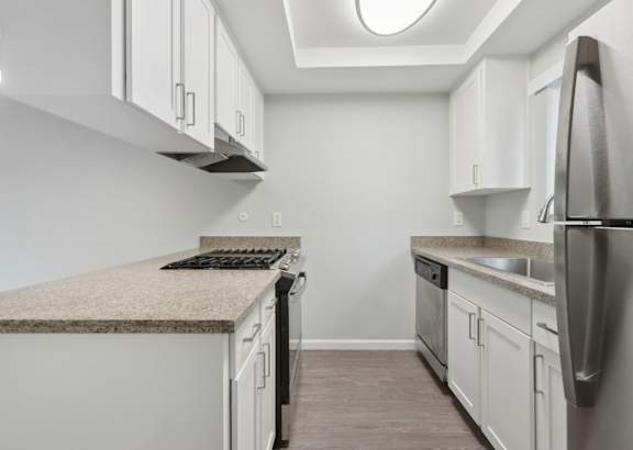 A kitchen with a granite countertop and stainless steel appliances.