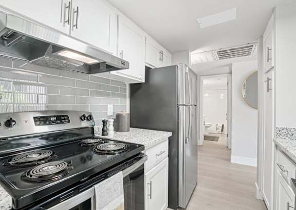 A kitchen with a granite countertop and stainless steel appliances.