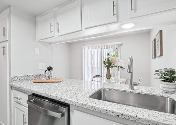 A kitchen with a granite countertop and stainless steel appliances.