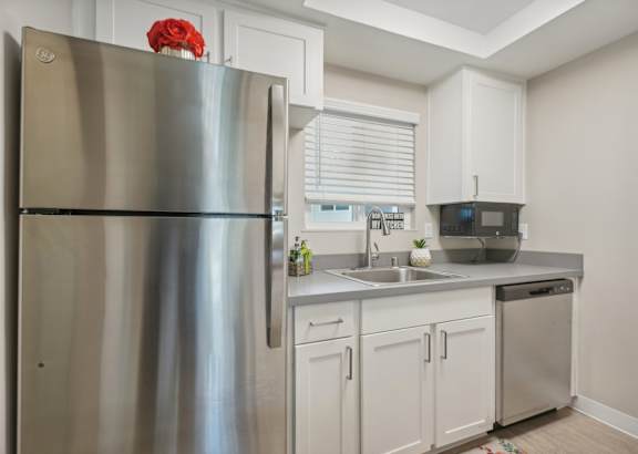 a kitchen with stainless steel appliances and white cabinets