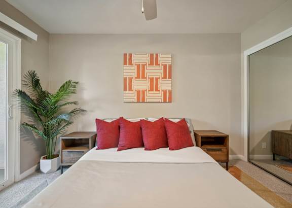 a bedroom with a large bed and a painting on the wall