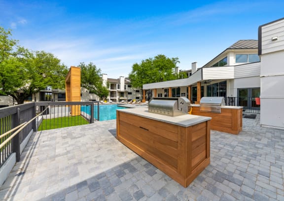 a patio with a grill and a swimming pool