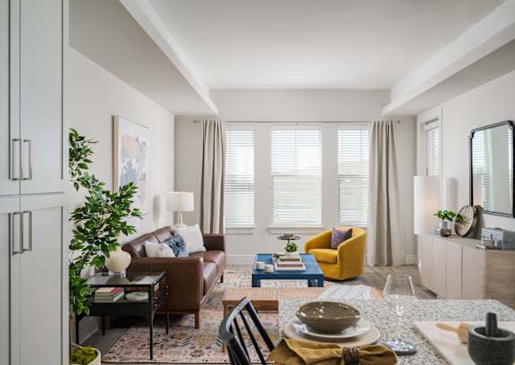 A well-lit, modern living room with a dining table set for two.