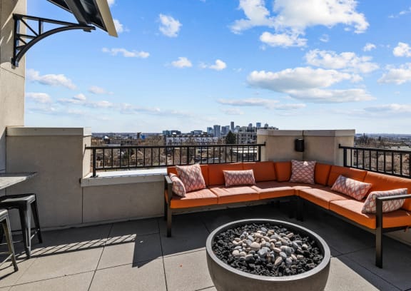 a rooftop patio with couches and a fire pit and a view of the city at Alton Jefferson Park, Denver Colorado