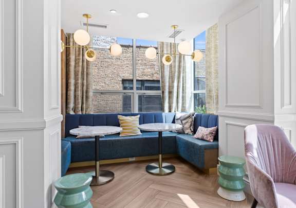 A room with a blue couch and a pink chair.