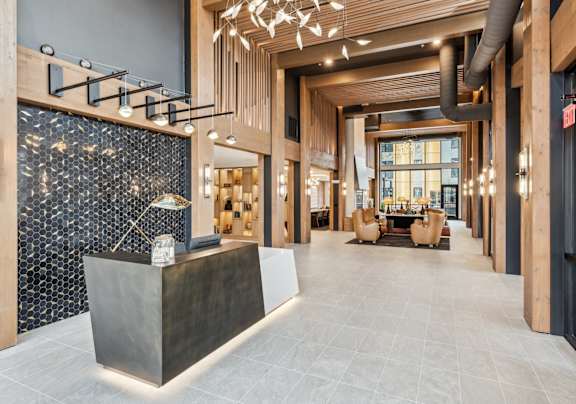 A modern lobby with a reception desk and a large window.