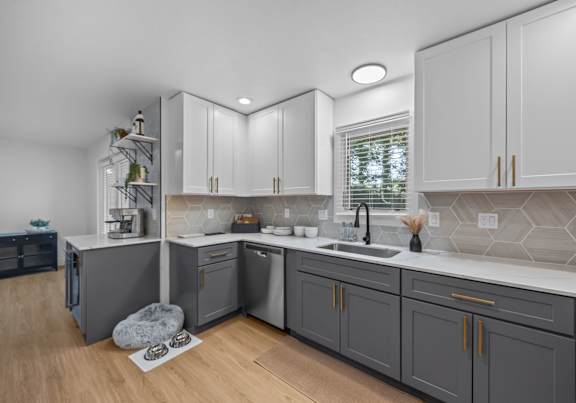 A modern kitchen with a sink, stove, and cabinets.