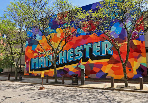 A large mural on a building with the word "MANCHESTER" written on it.