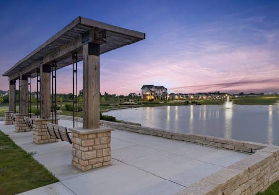 a pavilion overlooking a lake at sunset