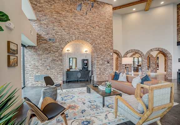 a living room with furniture and a brick wall