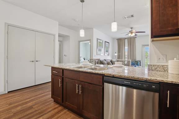 A modern kitchen with a stainless steel dishwasher and wooden cabinets.