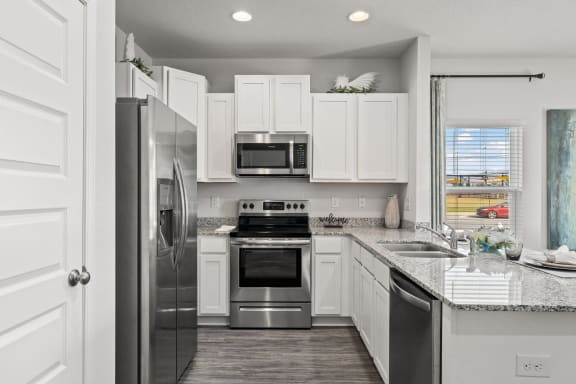 a kitchen with stainless steel appliances and white cabinets