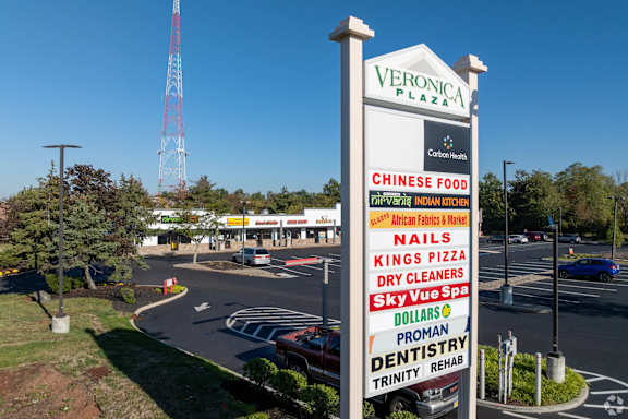 A sign for Veronica Plaza with various businesses listed on it.