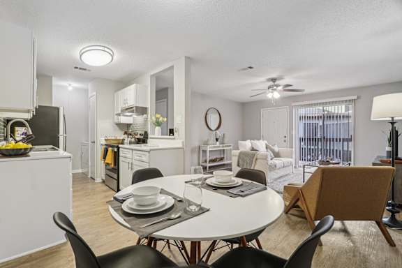 A modern dining room with a white table and chairs.