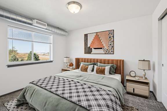 A room with a grey carpet and a sliding glass door leading to a balcony.