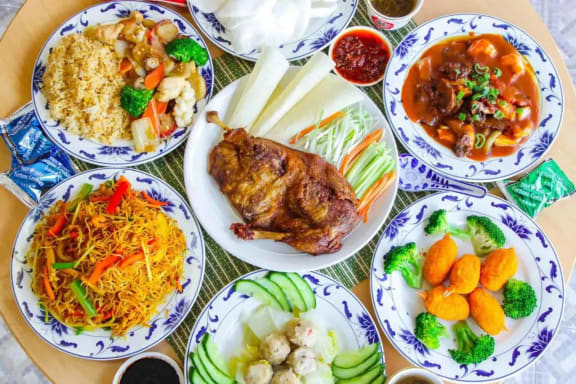 a table full of plates of food with meat and vegetables