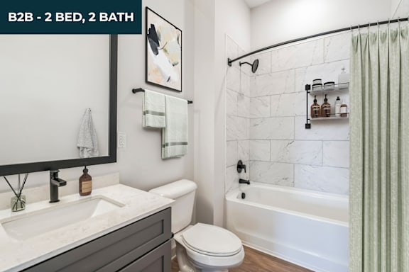 A bathroom with a white toilet, sink, and bathtub.
