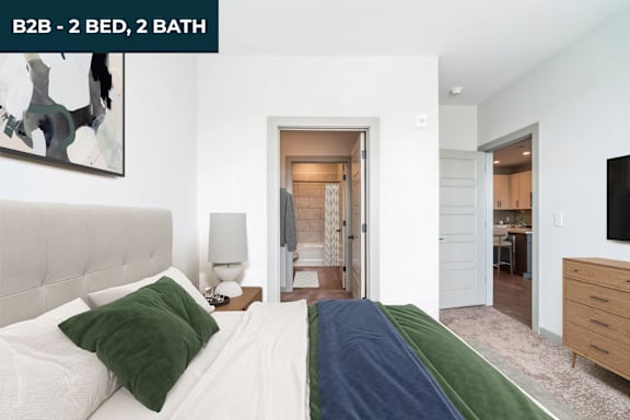 A bedroom with a bed, nightstand, and lamp.